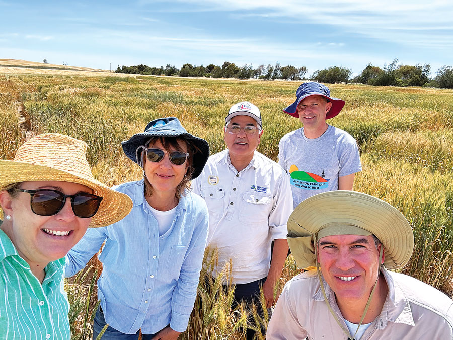 group of smiling researchers in a wheat field