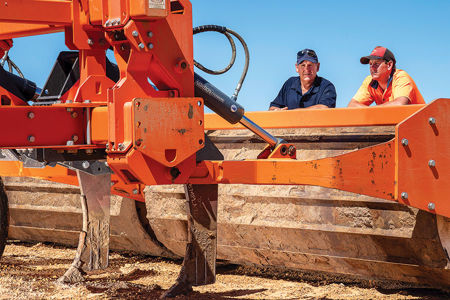 Two men leaning against farming machine