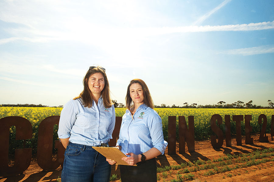 Kate Finger (left) and Dr Yolanda Plowman (right) standing in front of a canola paddock