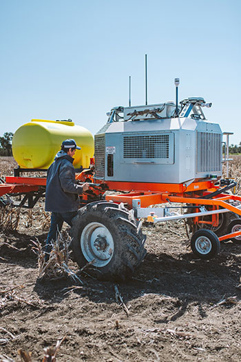 Man in field with farm machinery