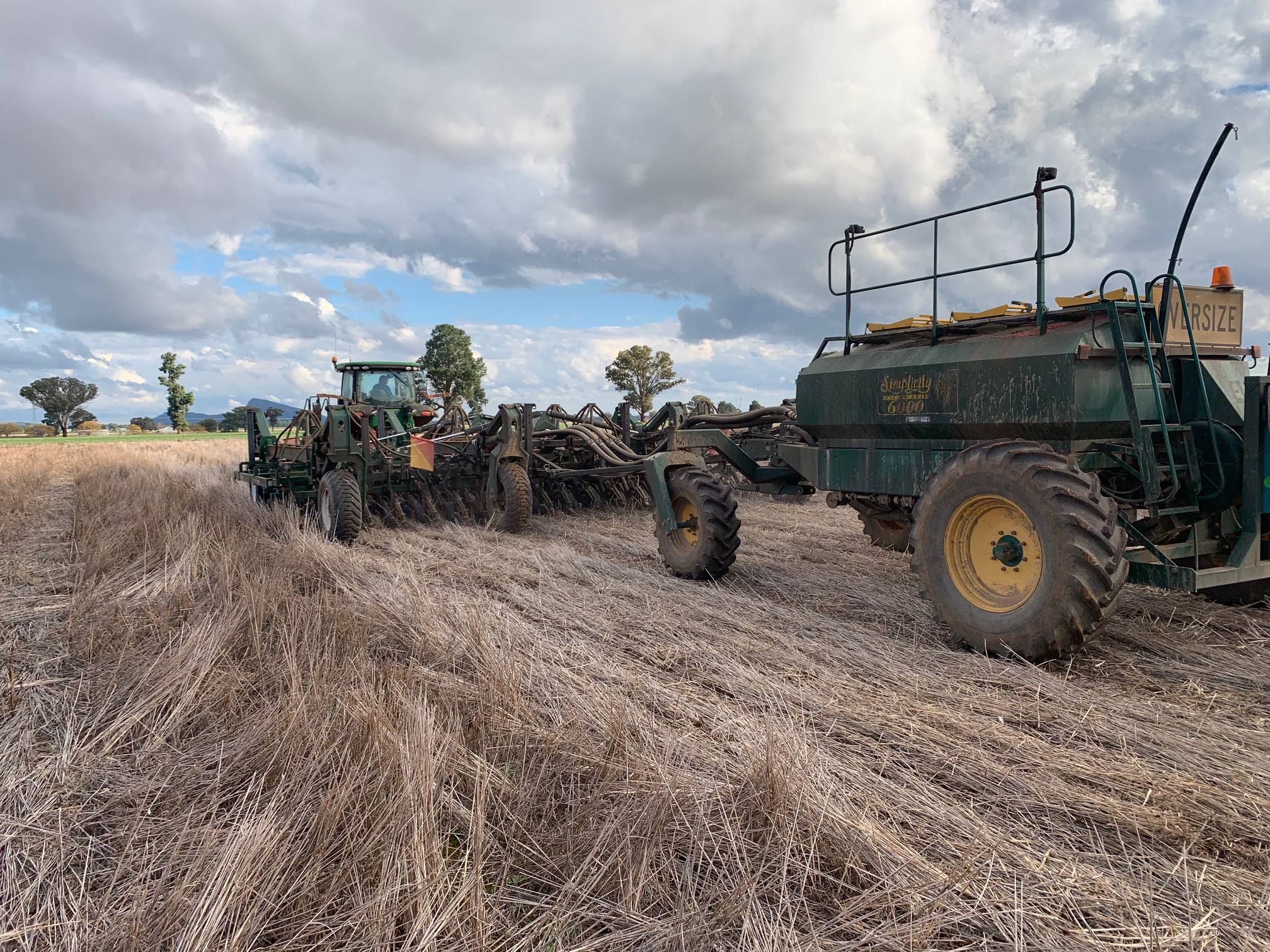 A picture of a paddock with a tractor and disc seeder sowing into stripper front stubble