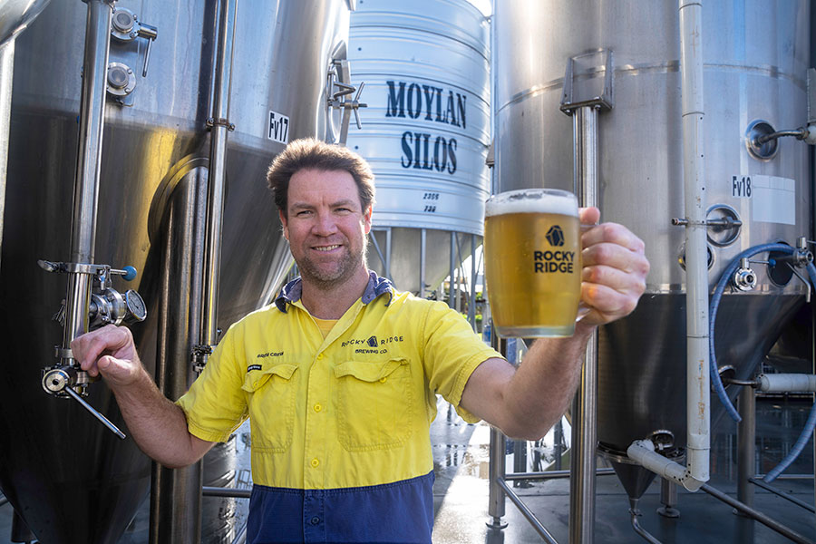 Drew Hennessy holding a glass of beer