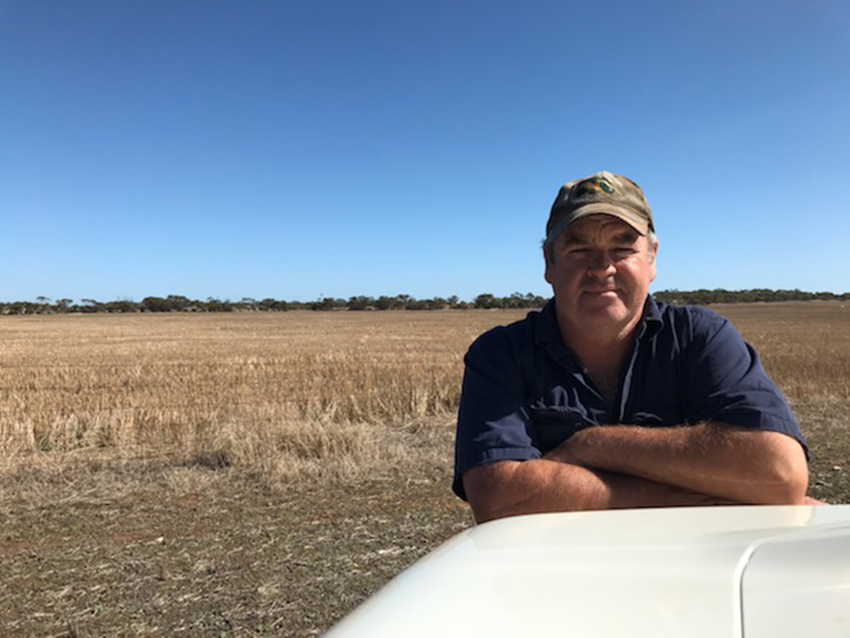 Scott Crettenden leaning on a ute in the paddock. 