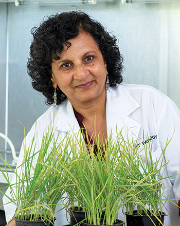 woman in white coat with pots of plants