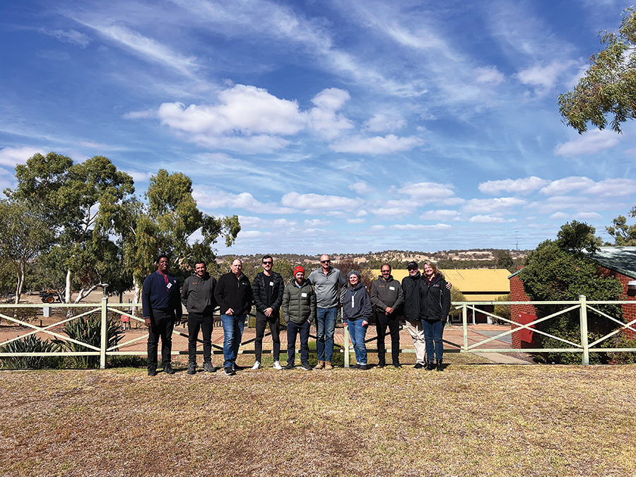 group standing in front of a fence on a sunny day