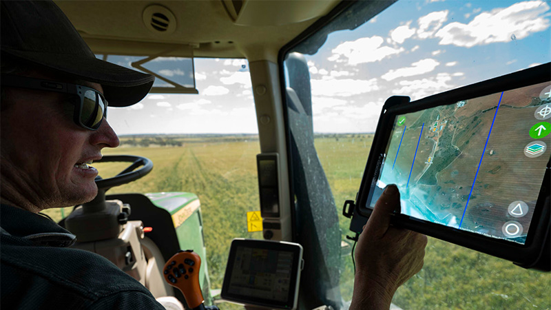 Image of grower using technology to navigate through his field.
