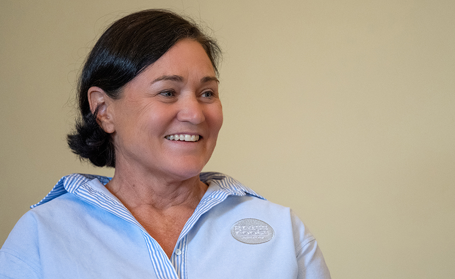 A woman with a blue shirt on, who is smiling