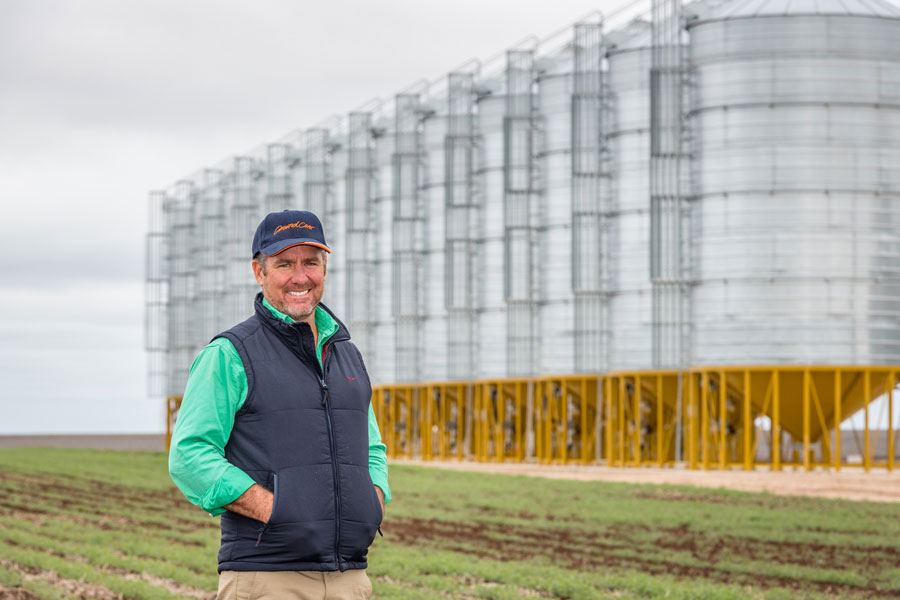 man standing in front of silos smiling to camera