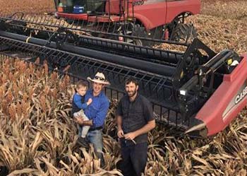 Andrew Milla, holding his son Cooper, with contract harvester Joel Rauchle says he has had a good start this year after a poor season in 2019