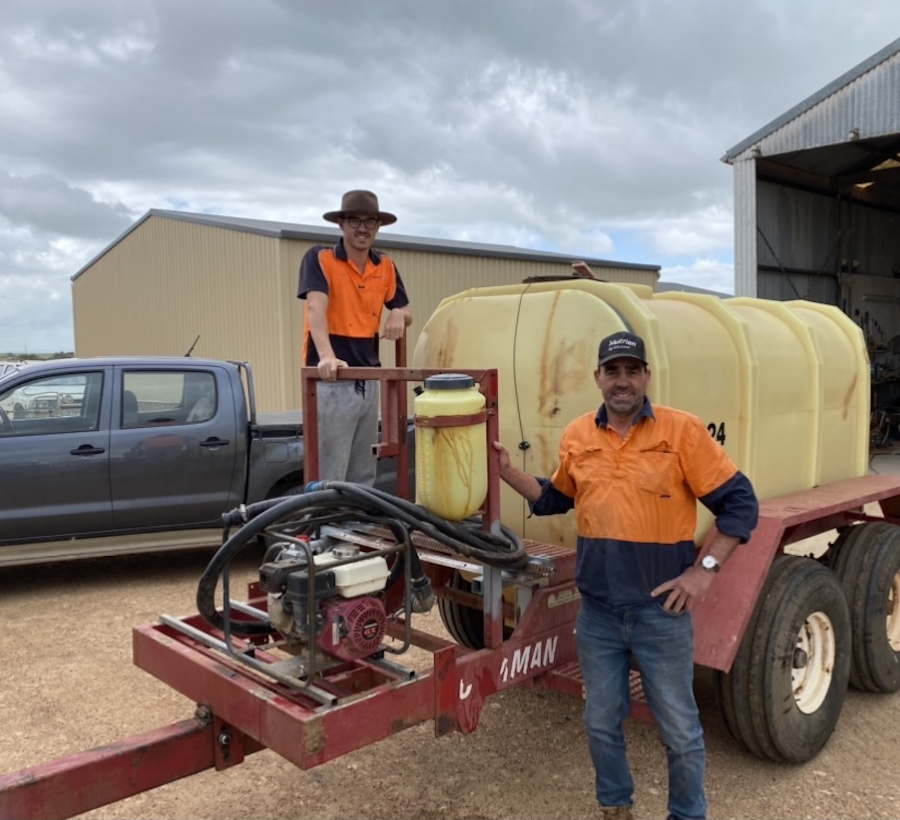 Michael Treloar and his nephew Jack with a tractor-towed boomspray used to fight fire. 