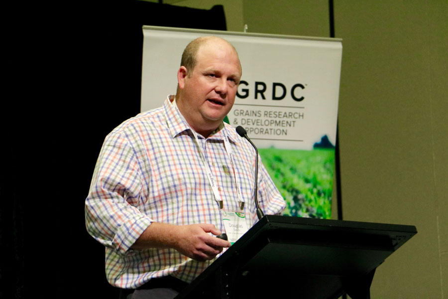 Doug Sands speaking at a lectern with a GRDC banner behind him.