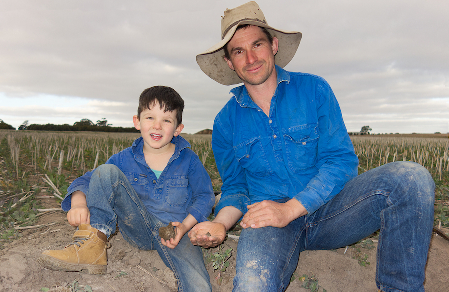 Mitchell and Todd Venning with handfuls of heavy clay soil. 