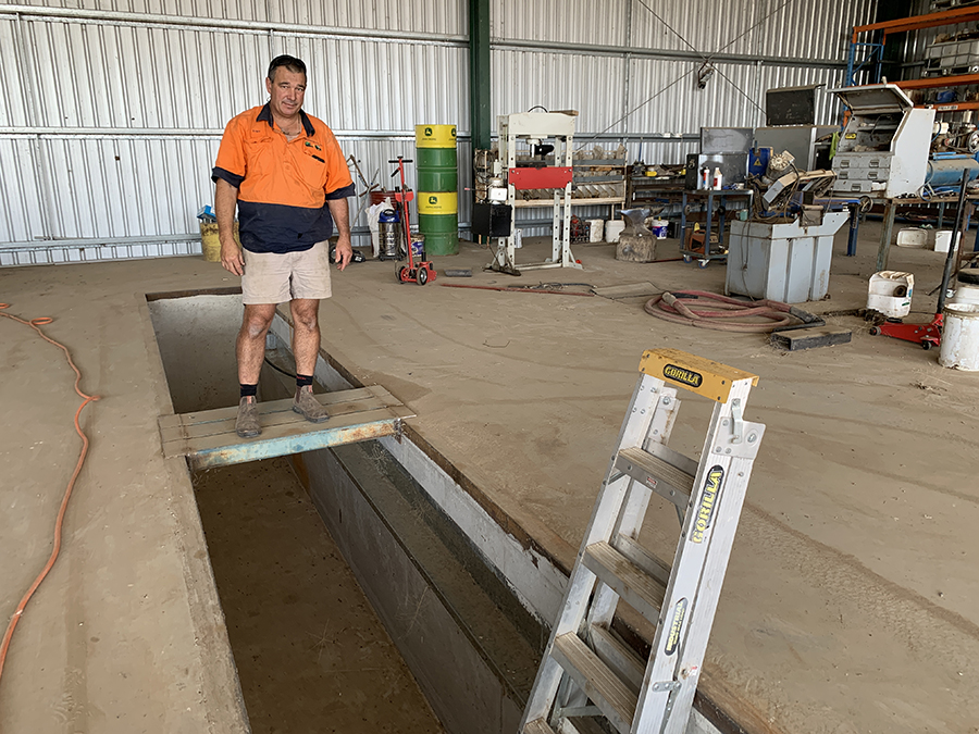 roger bolte standing next to a pit for maintaining his family's disc seeder