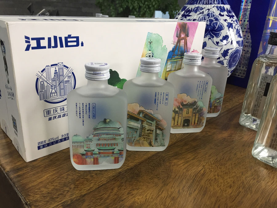 A photo of four different bottles of baiju on a table in front of a baiju box.
